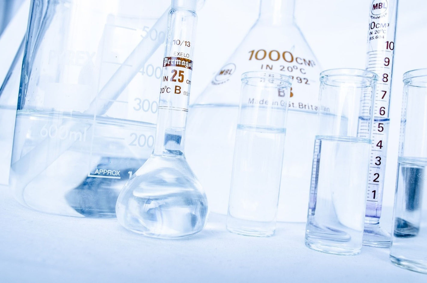 Analytical lab glassware measuring cylinders flasks and beakers containing water